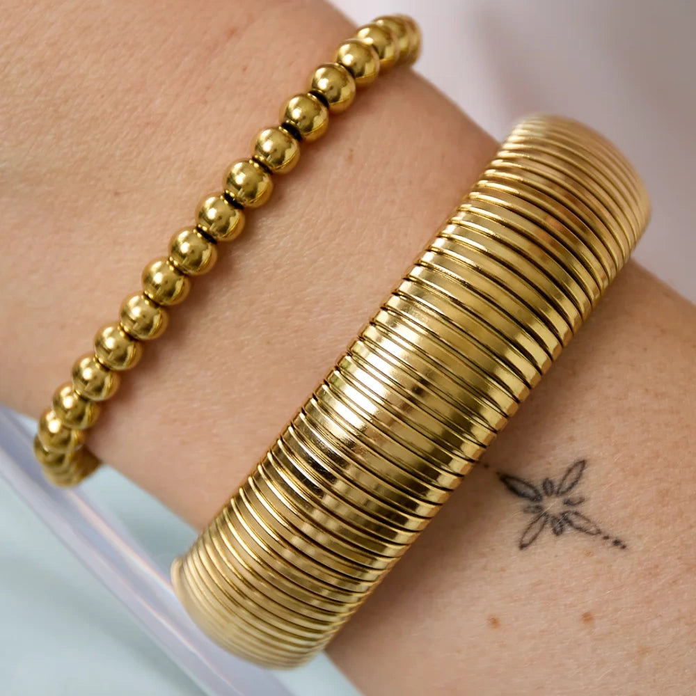 Goudkleurige elastische stainless steel armband met ronde kralen van 6 mm.