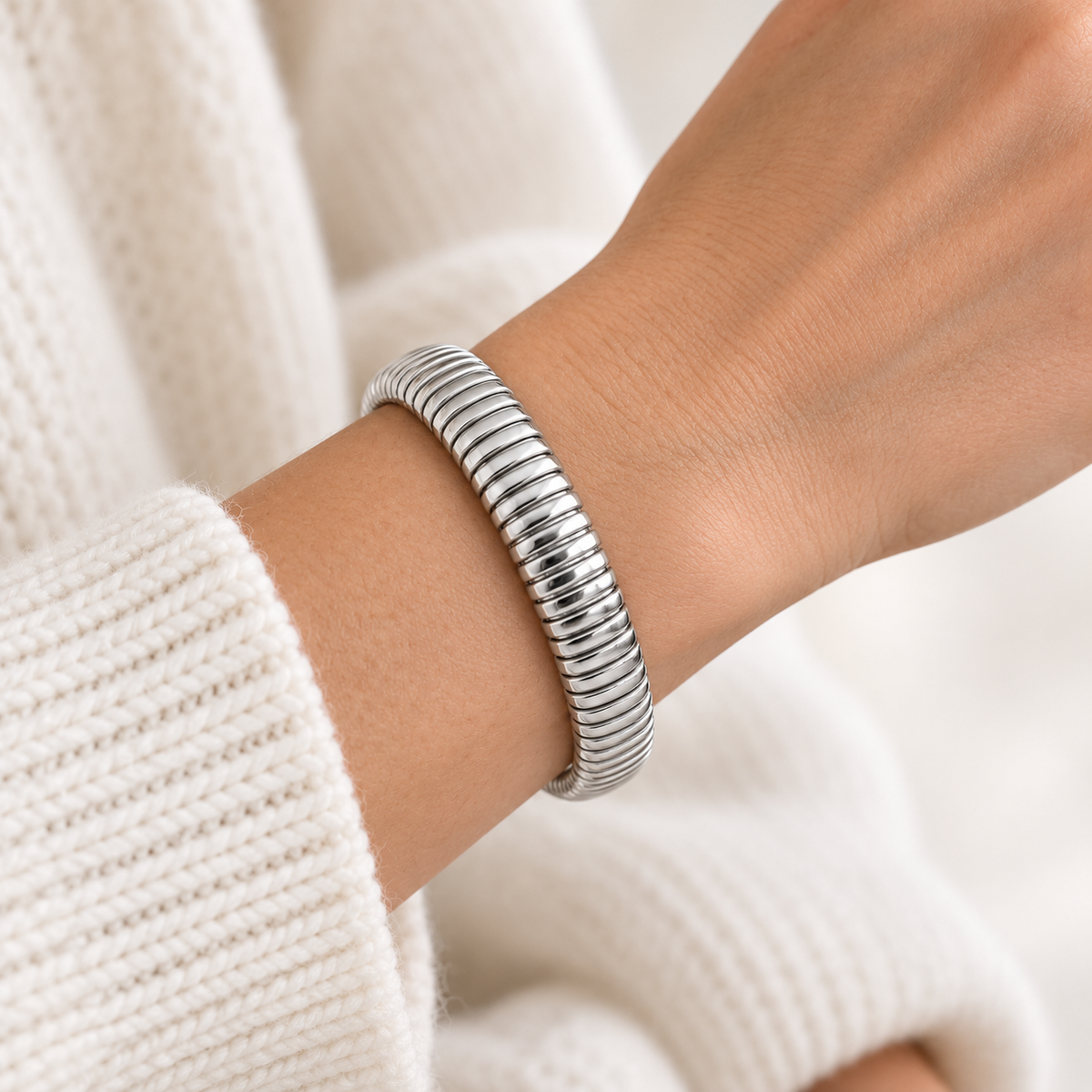 Zilverkleurige elastische armband met ribbelstructuur op pols